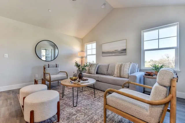 a living room with fireplace a mirror and a table