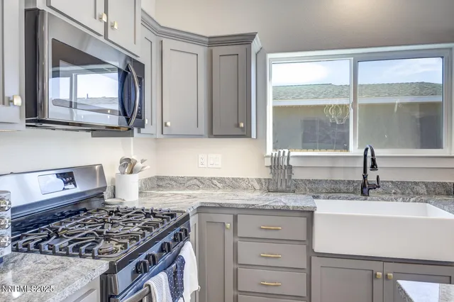 a kitchen with granite countertop a sink stove and cabinets