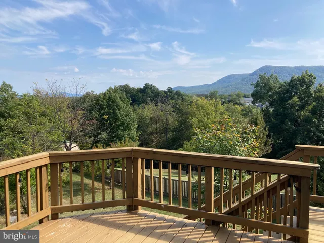 an empty room with wooden floor fireplace and windows