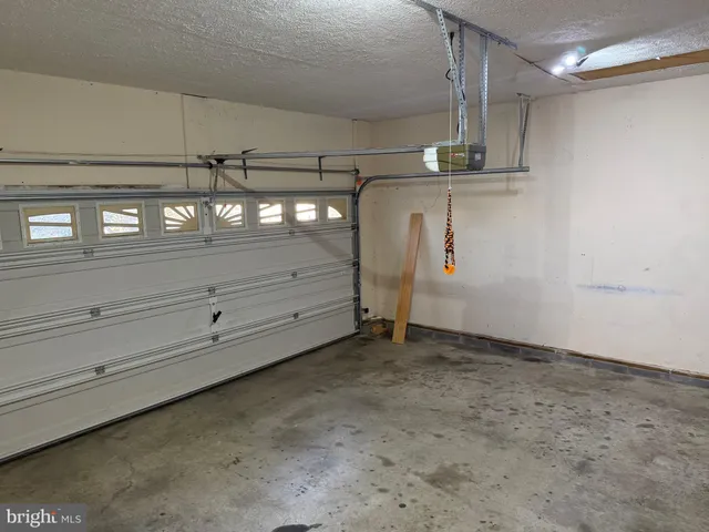 a view of an empty room with wooden floor fireplace and a window