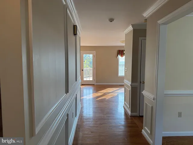 an empty room with wooden floor closet and windows