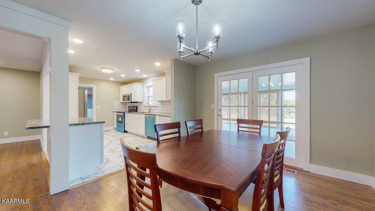 3877 Riverview Road Lenoir City, TN 37771 - Photo 18 of 47 a dining room with wooden floor and chandelier