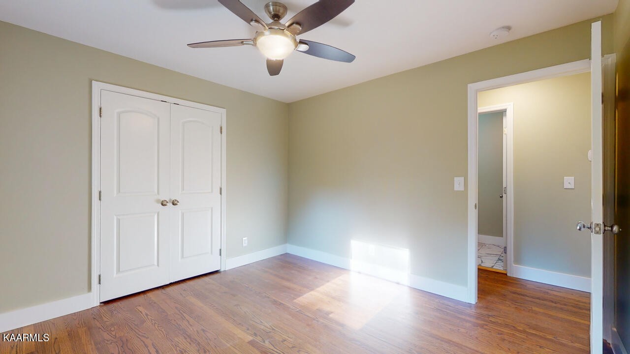 3877 Riverview Road Lenoir City, TN 37771 - Photo 27 of 47 an empty room with wooden floor and a ceiling fan