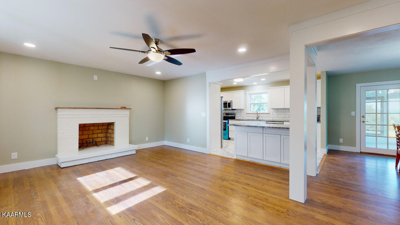 3877 Riverview Road Lenoir City, TN 37771 - Photo 9 of 47 a view of an empty room and kitchen with fireplace wooden floor