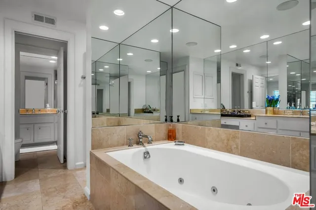 a bathroom with a tub a sink shower and mirror