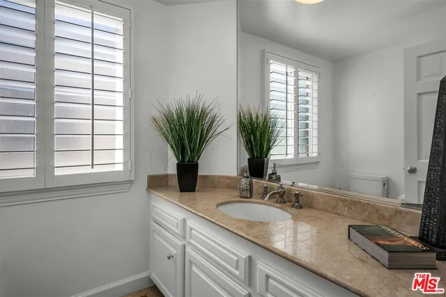 a bathroom with a granite countertop sink a mirror and a window