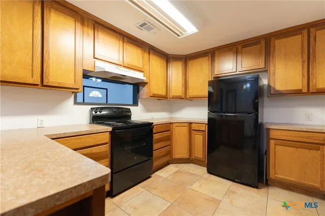 a kitchen with granite countertop stainless steel appliances and refrigerator