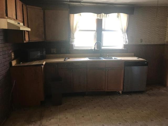 30795 North 1700 E Road Blackstone, IL 61313 - Photo 4 of 19 a view of a kitchen with a sink wooden cabinets and a window