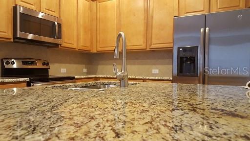 7652 Ripplepointe Way Windermere, FL 34786 - Photo 8 of 21 a view of a refrigerator a stove and a microwave