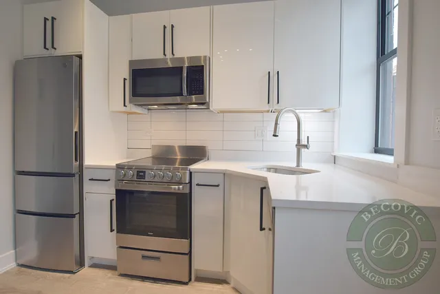 a kitchen with stainless steel appliances a stove a microwave and a refrigerator