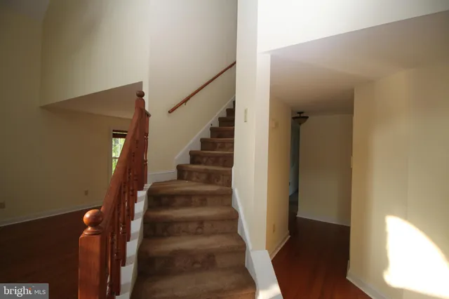 a view of staircase with wooden floor and white walls