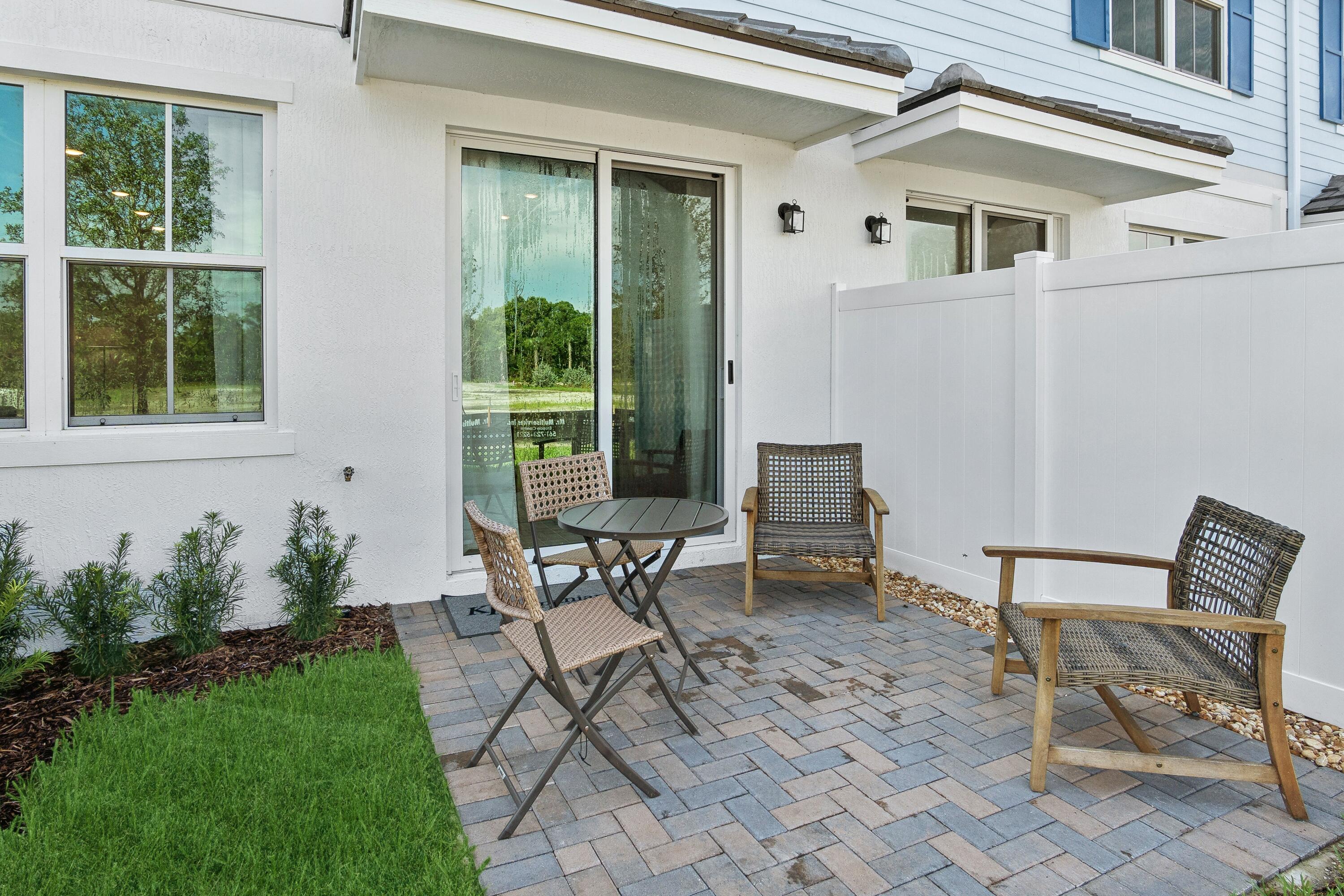 181 Southeast Birch Terrace, Unit 735 Stuart, FL 34997 - Photo 42 of 44 a view of a house with backyard sitting area and garden