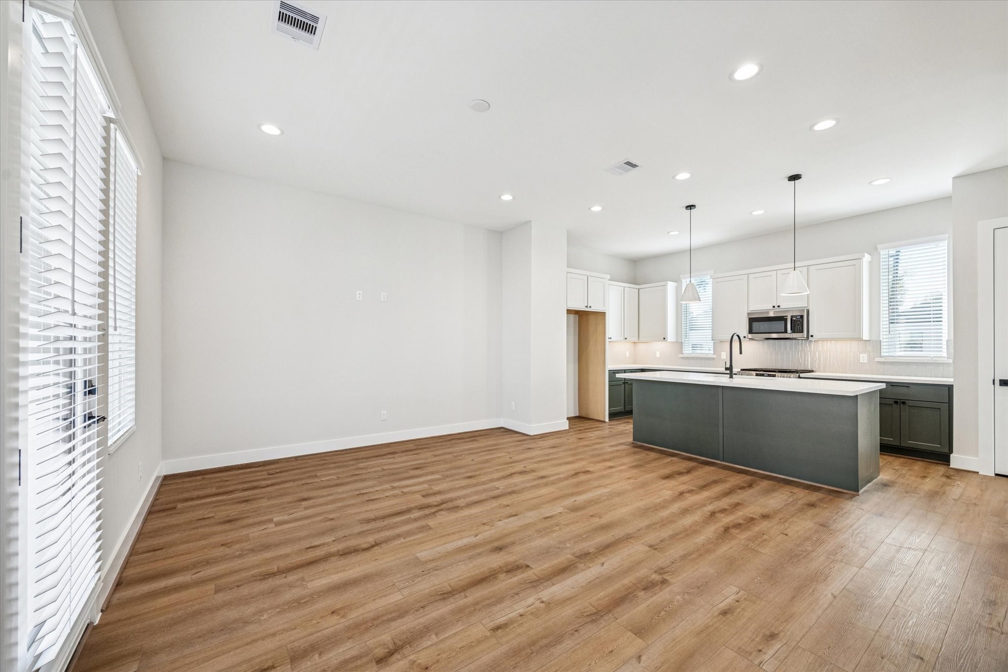 520 Janisch Road Houston, TX 77018 - Photo 10 of 28 a large kitchen with kitchen island a sink wooden floor and stainless steel appliances