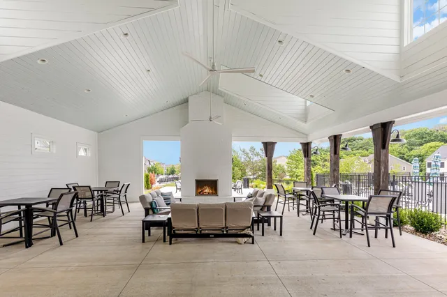 a room with lots of tables a large window and chairs