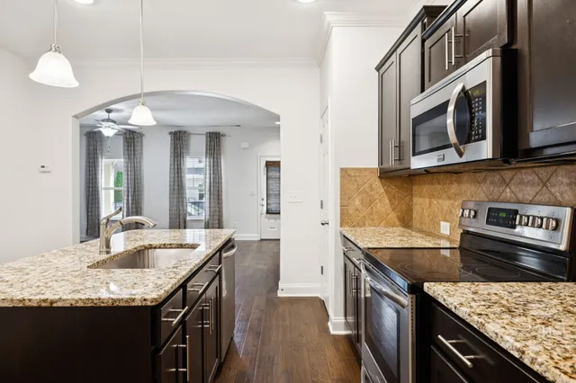 a kitchen with stainless steel appliances granite countertop a sink and stove