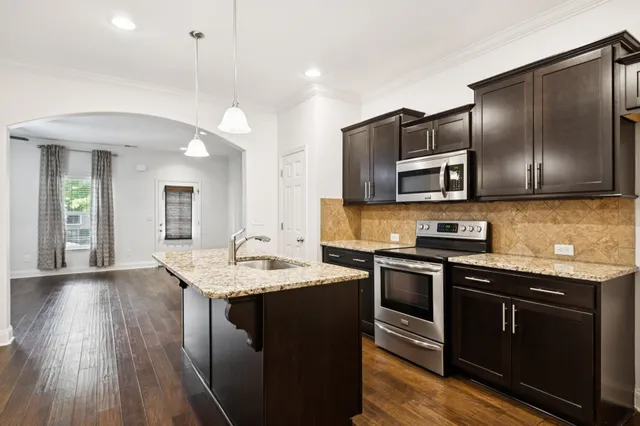 a kitchen with stainless steel appliances granite countertop a sink stove and microwave