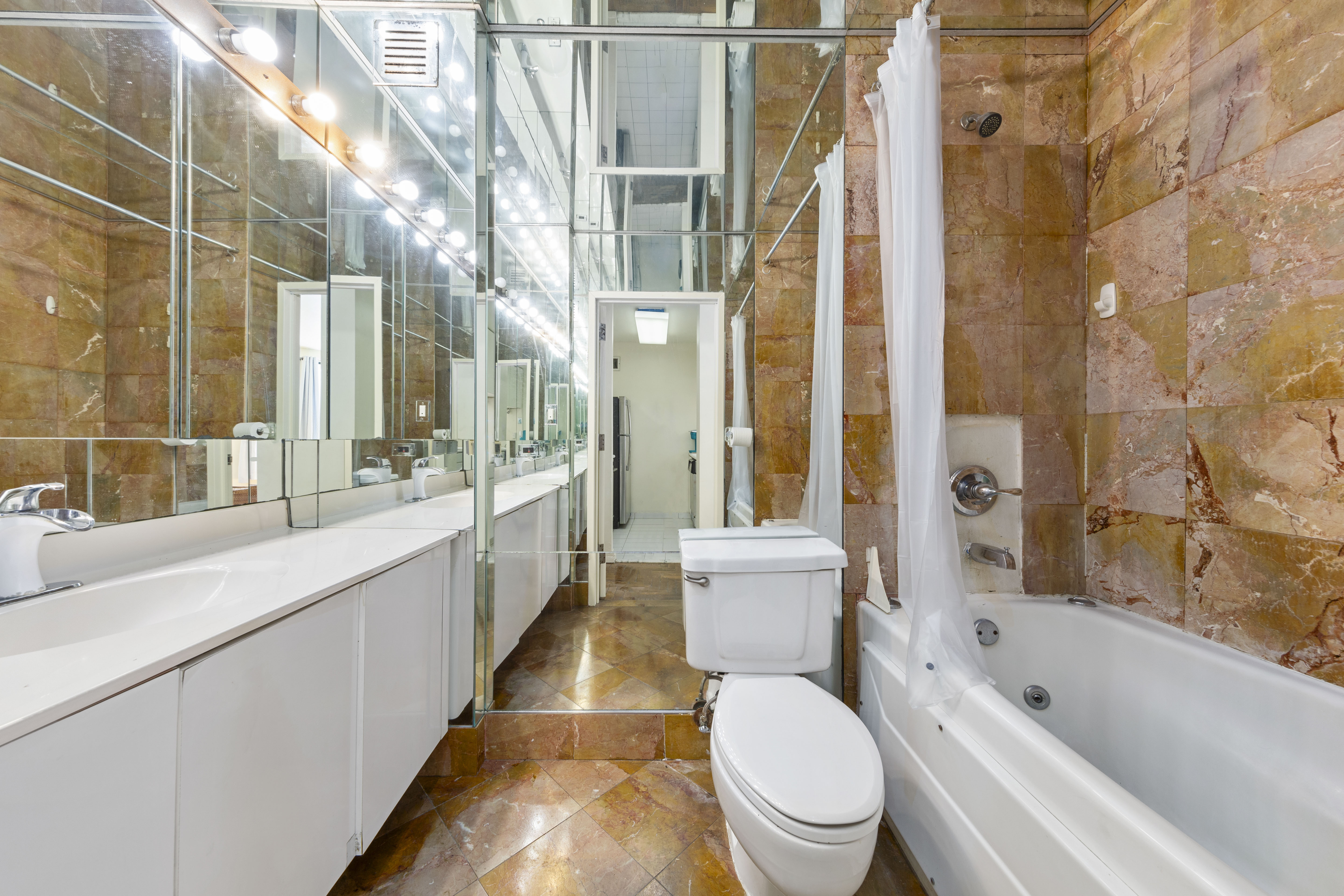 22 Perry Street, Unit 2B Manhattan, NY 10014 - Photo 7 of 9 a bathroom with a granite countertop bathtub sink vanity mirror and toilet