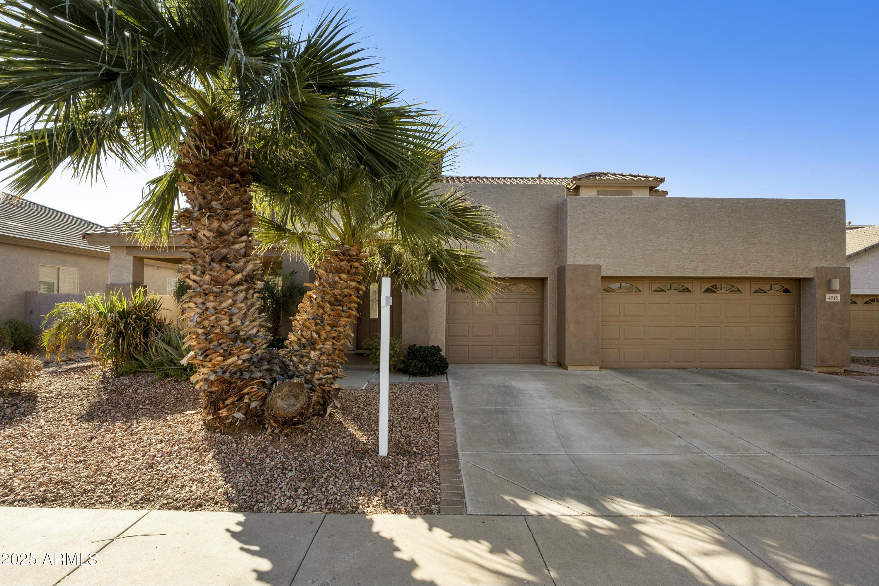a view of a house with a yard and palm trees