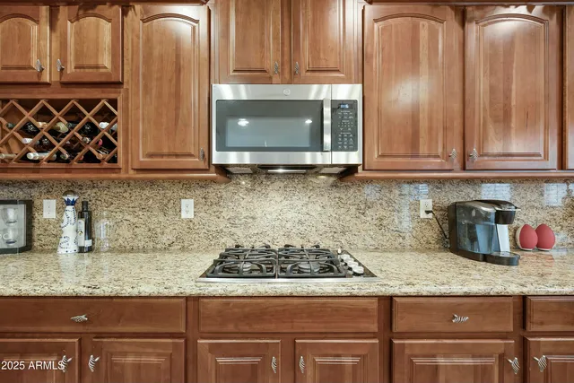 a kitchen with granite countertop a stove top oven microwave and cabinets