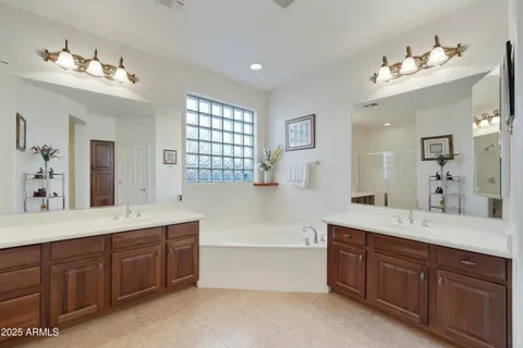 a spacious bathroom with a tub double sink and mirror