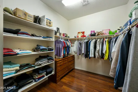 a view of walk in closet with clothes and shoes