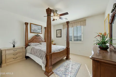 a bedroom with a bed and a potted plant on the dresser