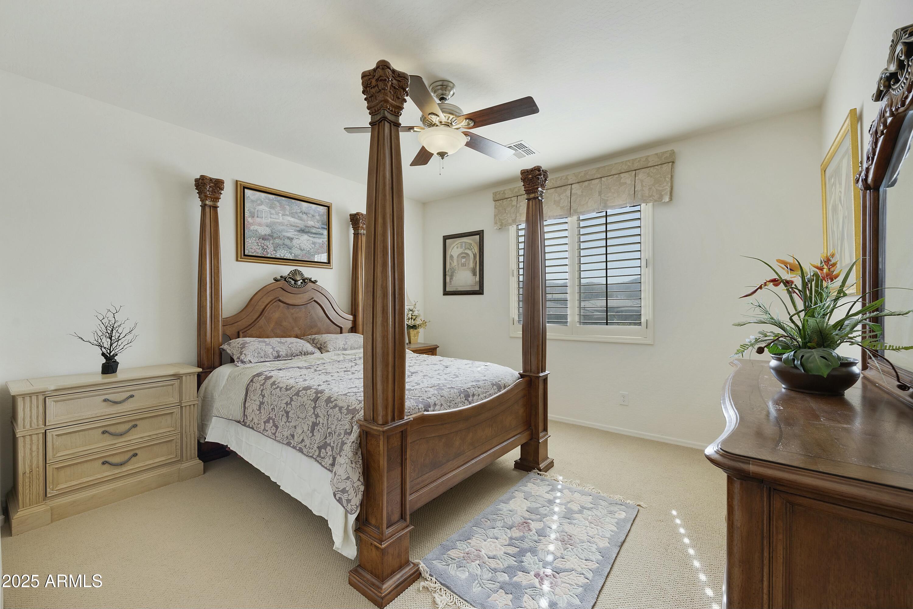 4615 West Corral Road Laveen, AZ 85339 - Photo 32 of 48 a bedroom with a bed and a potted plant on the dresser