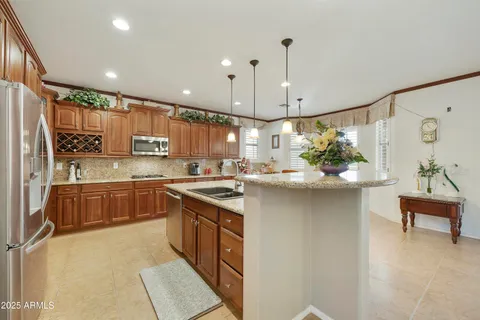 a kitchen with stainless steel appliances granite countertop a sink a stove and a refrigerator