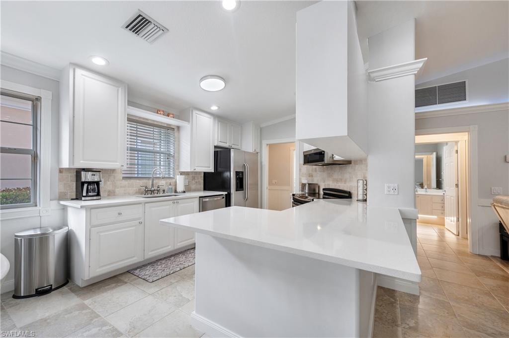 7221 Bellini Way Naples, FL 34114 - Photo 17 of 43 a large kitchen with kitchen island a sink a center island stainless steel appliances and a cabinets