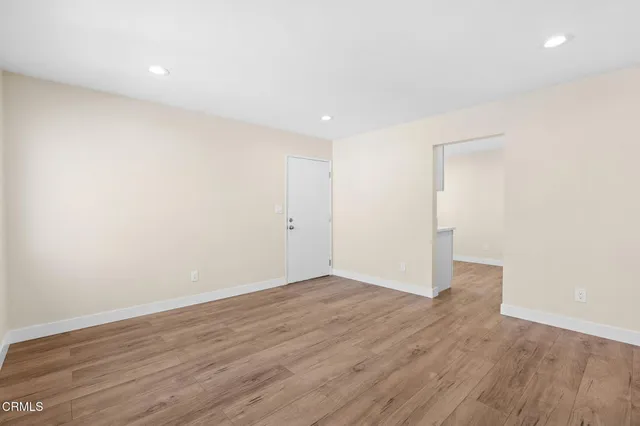 a view of an empty room with wooden floor
