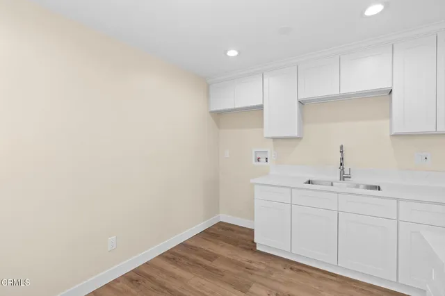 a room with a sink cabinets and utility