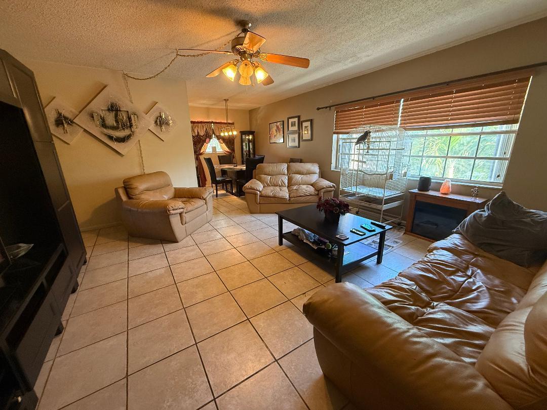 1985 Northeast 32nd Court, Unit 49 Lighthouse Point, FL 33064 - Photo 2 of 8 a living room with furniture and a flat screen tv