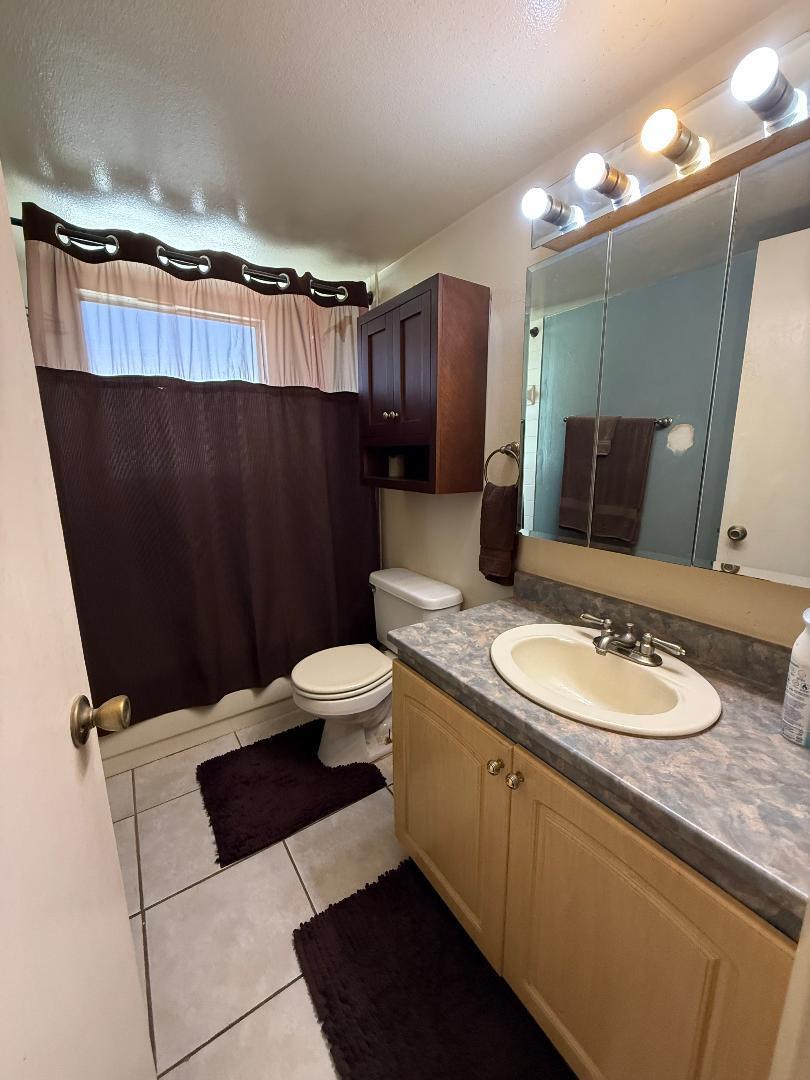 1985 Northeast 32nd Court, Unit 49 Lighthouse Point, FL 33064 - Photo 8 of 8 a bathroom with a sink a toilet a mirror and shower curtain