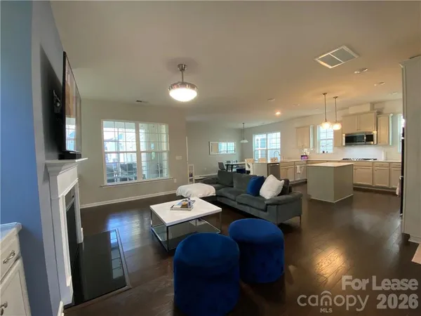 a large kitchen with kitchen island a stove a sink a refrigerator and a fireplace
