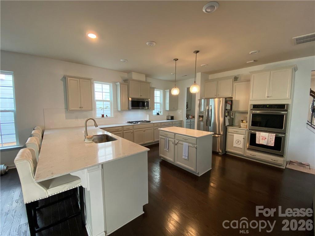 6434 Raffia Road Charlotte, NC 28277 - Photo 8 of 32 a large kitchen with kitchen island a stove a sink a refrigerator and a fireplace