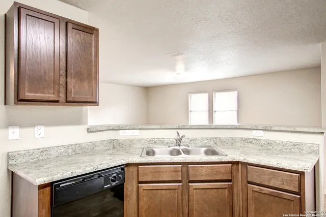a kitchen with granite countertop cabinets sink and window