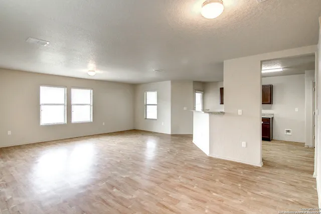 a view of empty room with wooden floor and windows