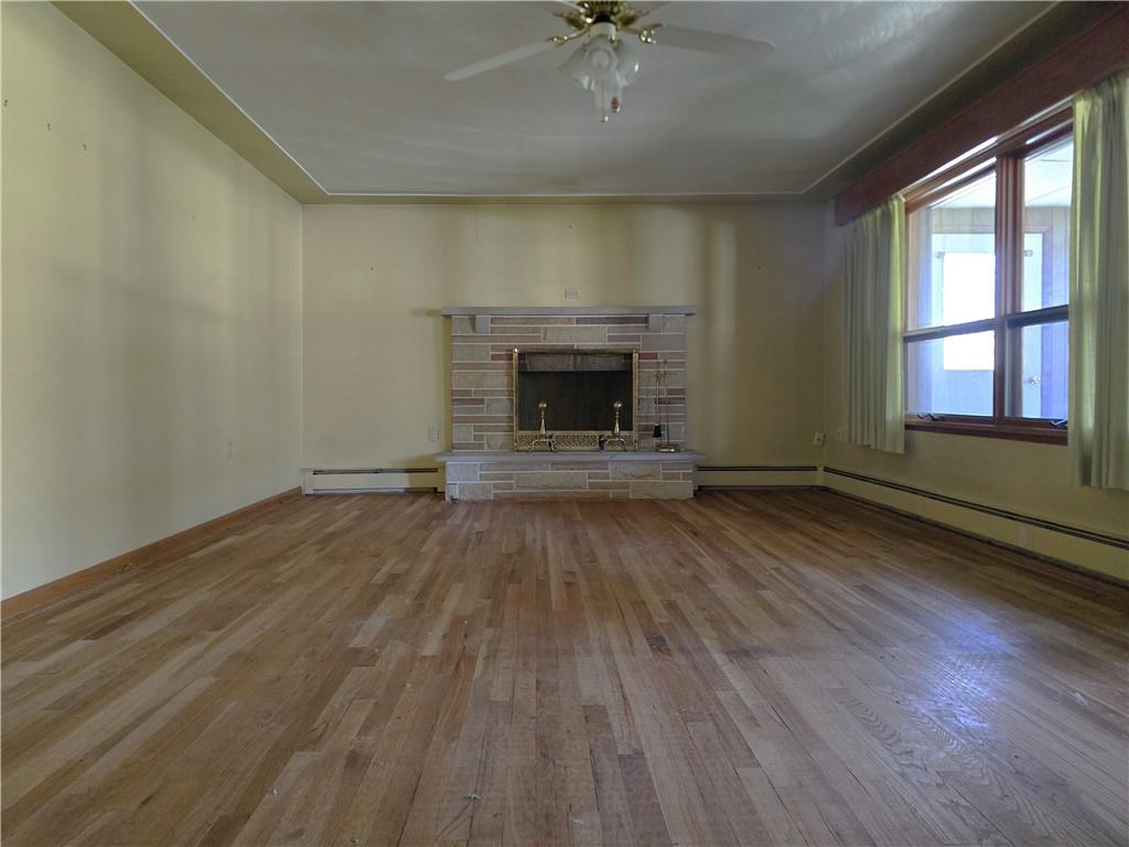 770 Pittsburgh Road Butler, PA 16002 - Photo 11 of 32 an empty room with wooden floor a fireplace and windows