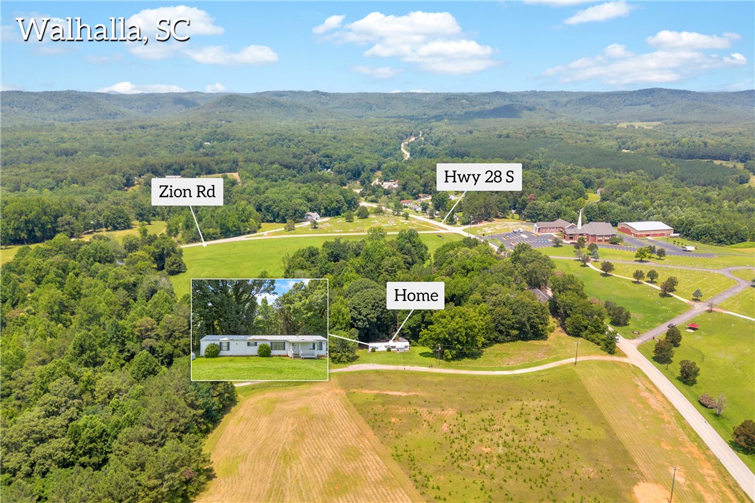 150 Newberry Road Walhalla, SC 29691 - Photo 39 of 47 An aerial perspective reveals a secluded property amidst vast green landscapes and wooded hills.