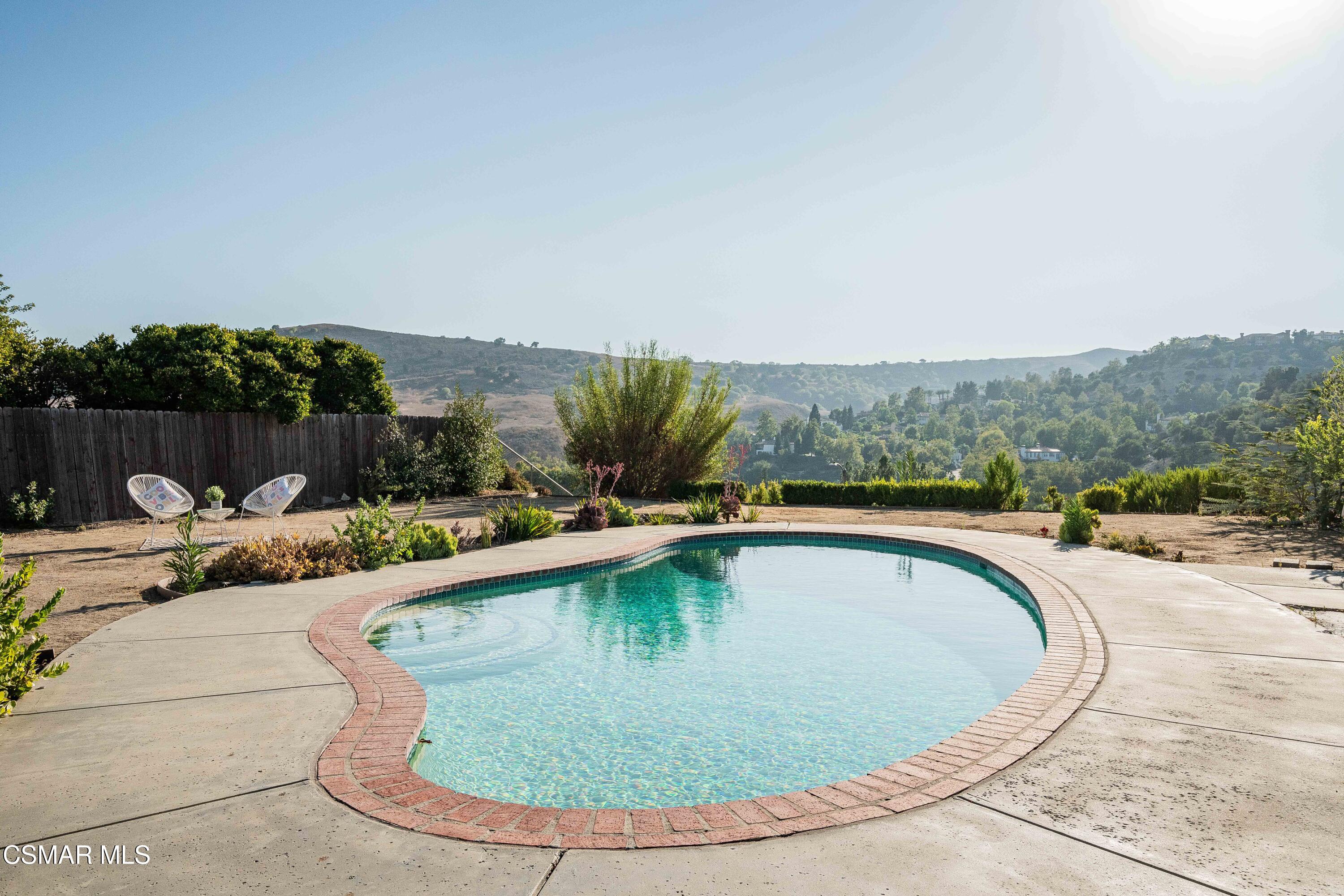5839 Parkmor Road Calabasas, CA 91302 - Photo 38 of 42 a view of a swimming pool with a lounge chair