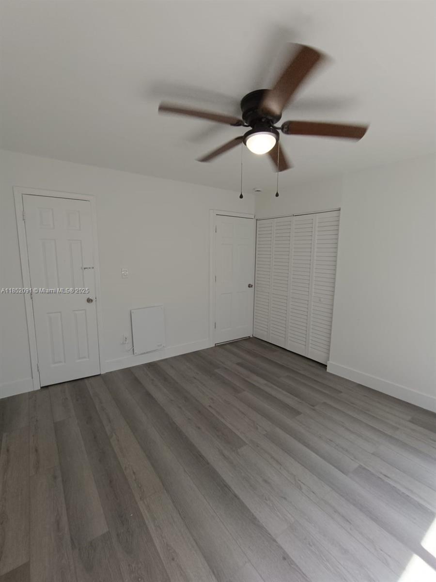 1857 Southwest 4th Street, Unit 3 Miami, FL 33135 - Photo 2 of 10 an empty room with wooden floor ceiling fan and window