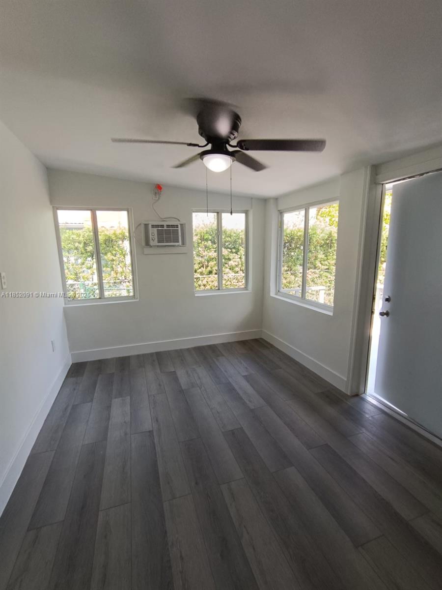 1857 Southwest 4th Street, Unit 3 Miami, FL 33135 - Photo 4 of 10 an empty room with wooden floor and windows