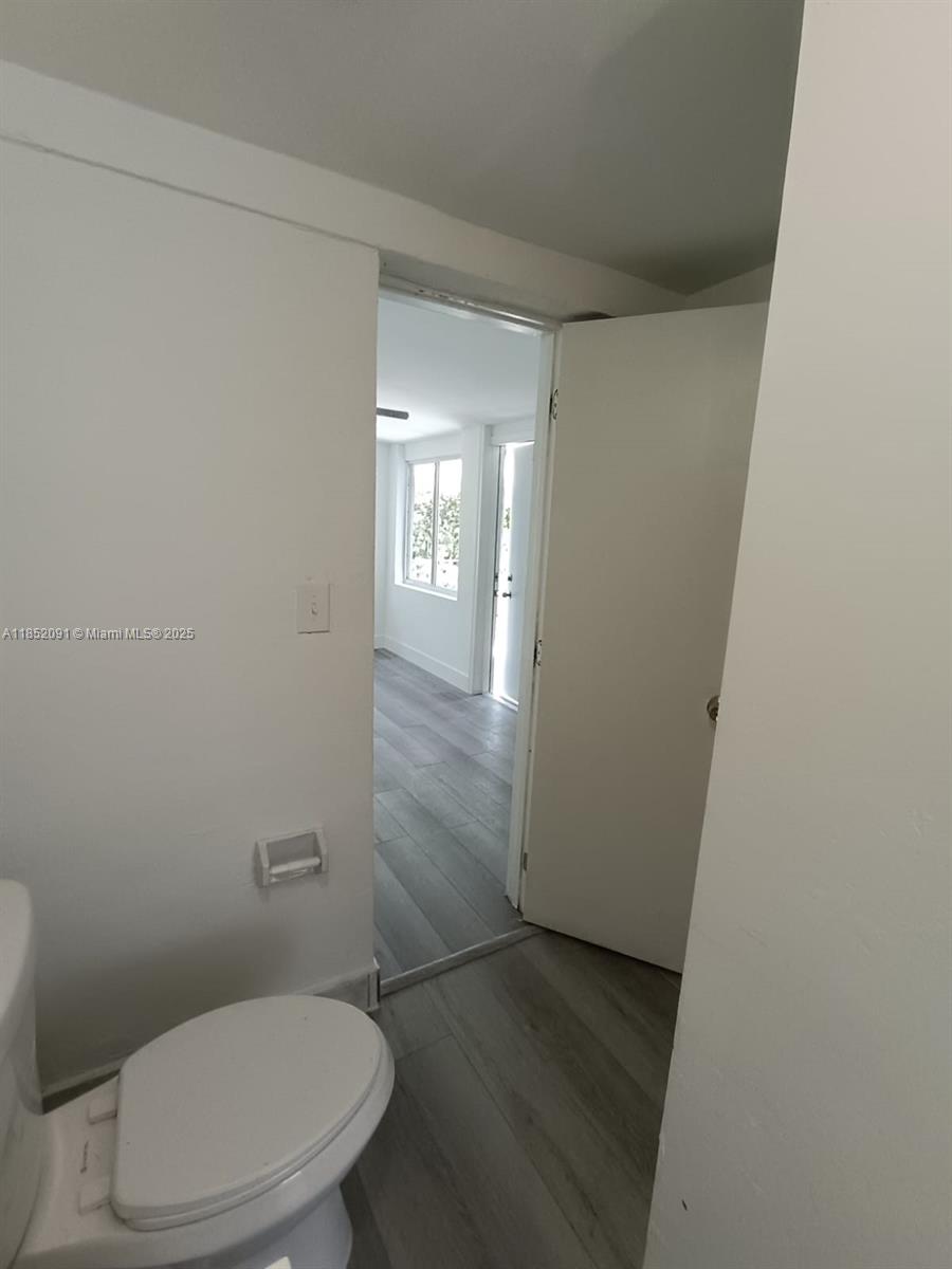 1857 Southwest 4th Street, Unit 3 Miami, FL 33135 - Photo 5 of 10 a white toilet sitting next to a shower curtain