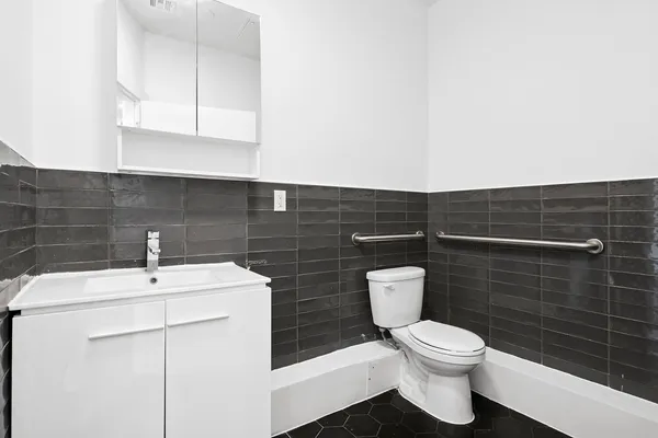 a bathroom with a toilet a sink and mirror