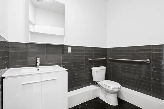 a bathroom with a toilet a sink and mirror