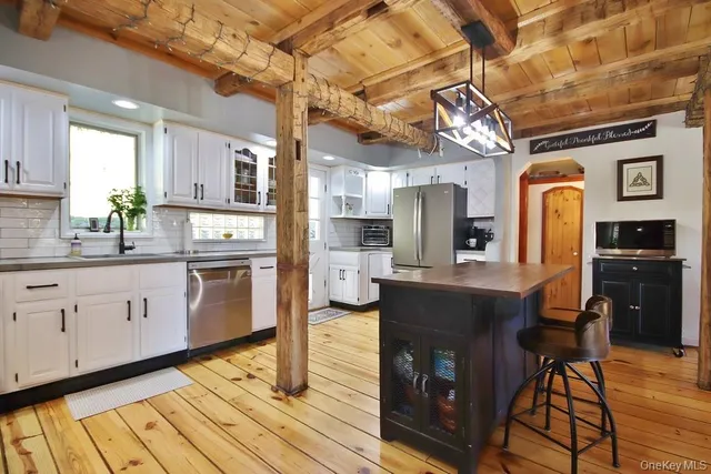 a open kitchen with stainless steel appliances granite countertop a stove a sink dishwasher and cabinets with wooden floor