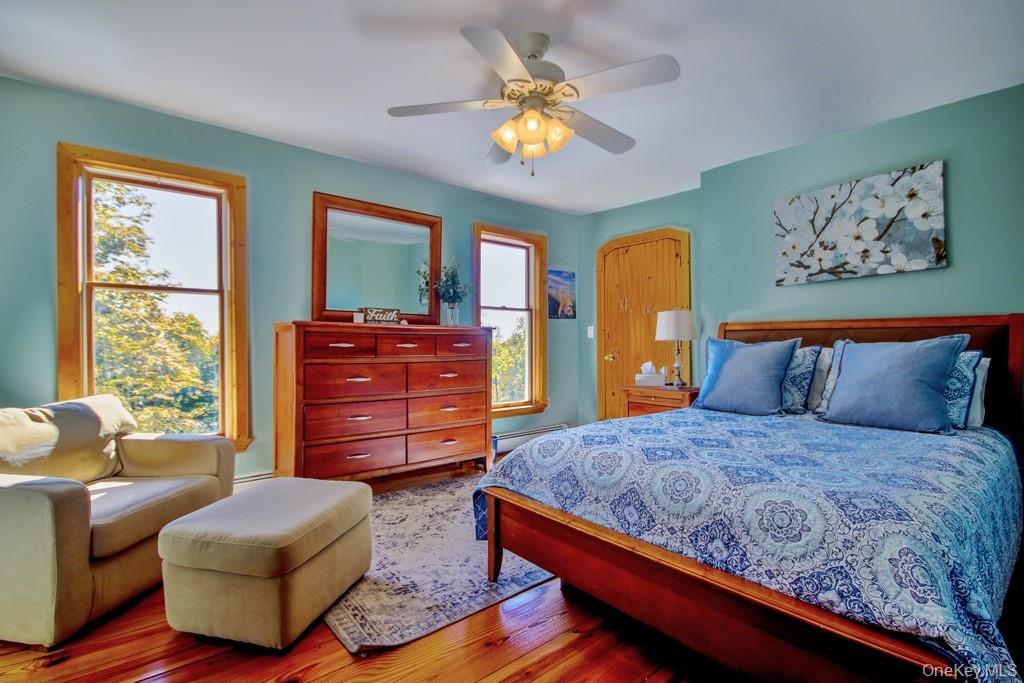 575 Roosa Gap Road Bloomingburg, NY 12721 - Photo 35 of 50 a bedroom with a bed and wooden floor