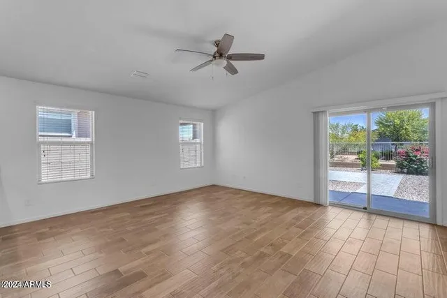 a view of a livingroom with a stove wooden cabinets and a window