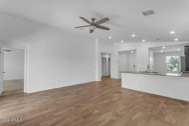 an empty room with windows and fan