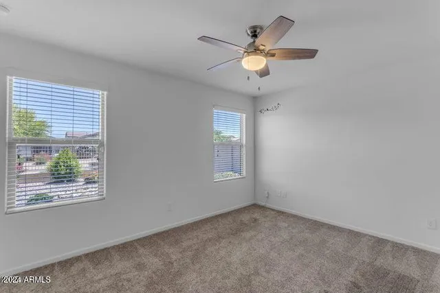 an empty room with closet and a ceiling fan